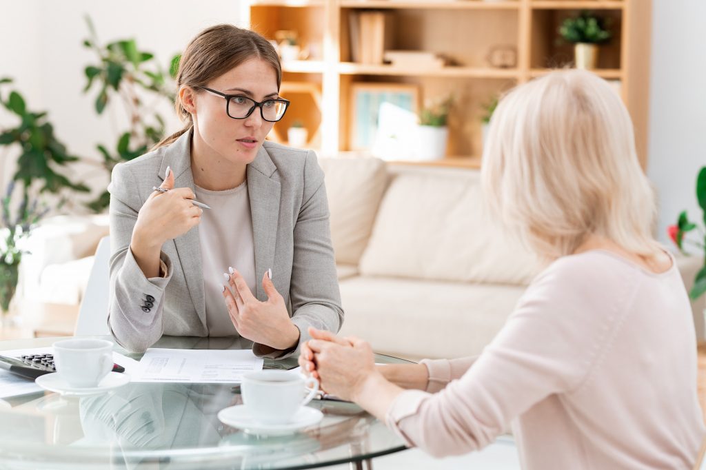 Young and mature accountants gathered by table for discussion of working points